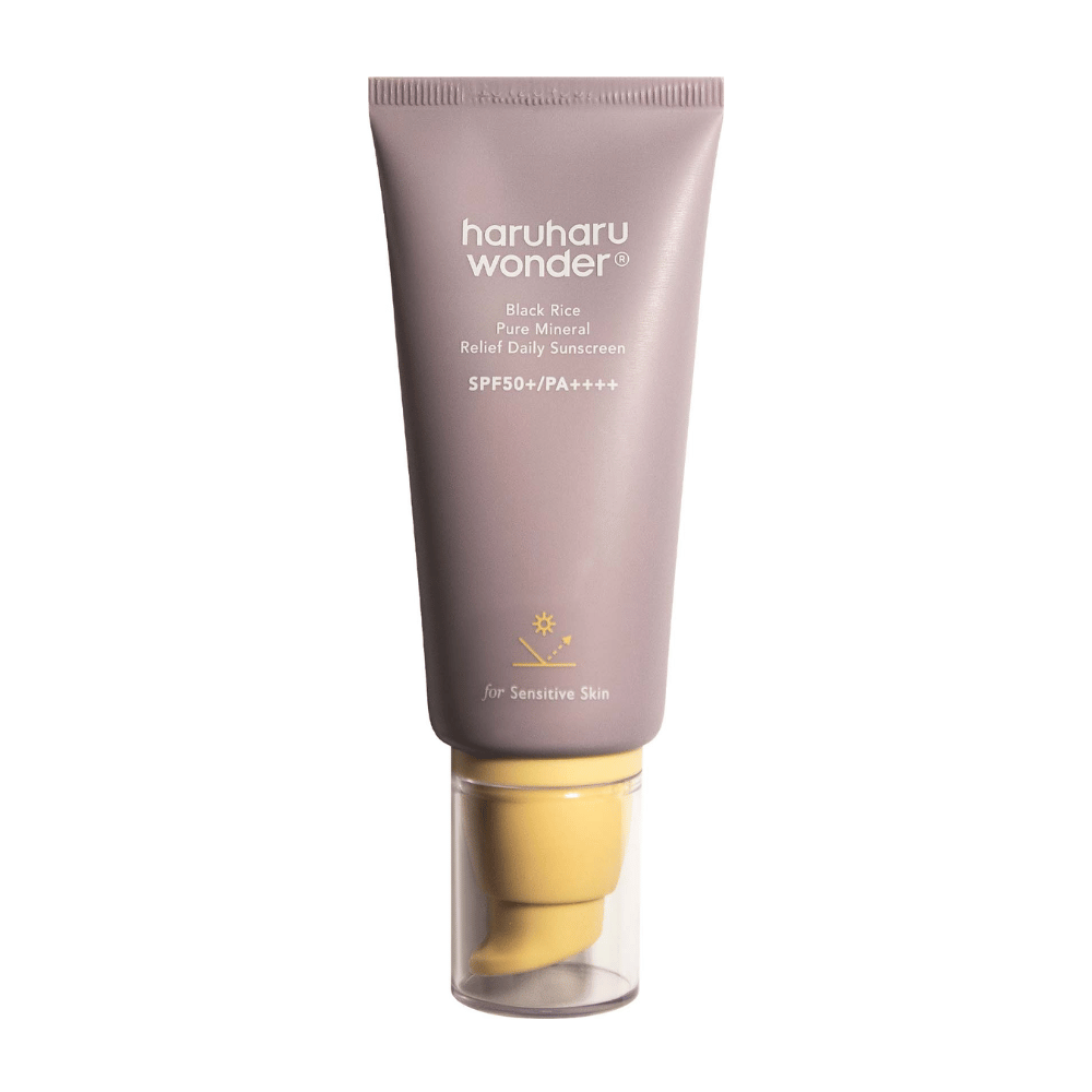 En lila tub med Haruharu Wonder Black Rice Pure Mineral Relief Daily Sunscreen SPF 50+ PA++++. Tuben har en genomskinlig kork och text som beskriver solkrämens höga skyddsnivå, speciellt anpassad för känslig hud.