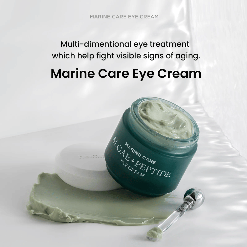 Heimish Marine Care Algae + Peptide Eye Cream i en öppen burk med grönaktig kräm. Krämen är utspridd bredvid burken och en applikator ligger intill. Produkten bekämpar ålderstecken och ger intensiv återfuktning.