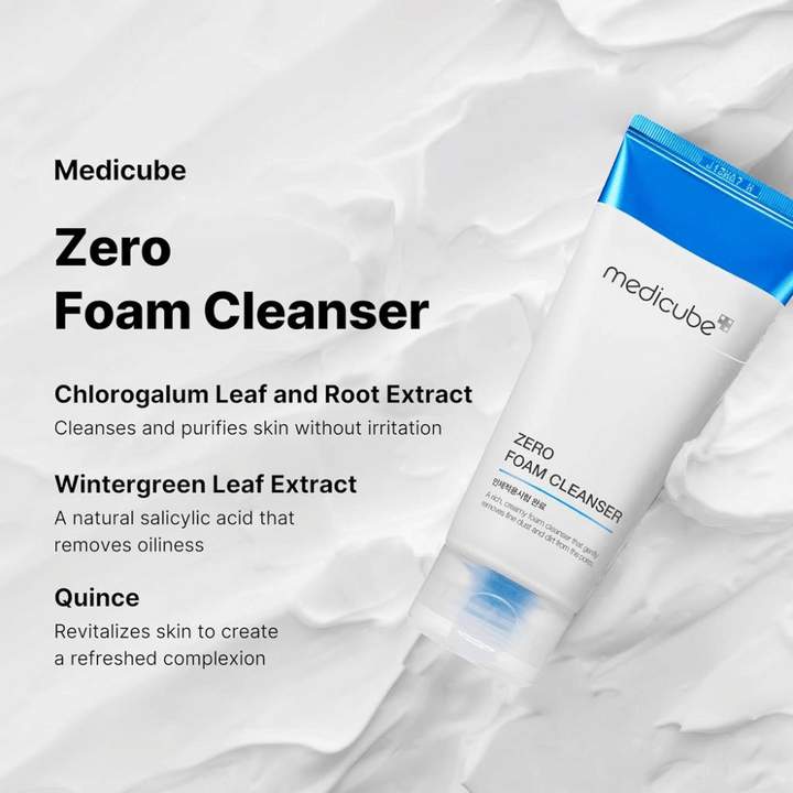 Medicube Zero Foam Cleanser med information om dess ingredienser och fördelar. Tuben är vit med blå detaljer och placerad mot en bakgrund av skum. Texten listar ingredienser: Chlorogalum blad- och rot-extrakt som rengör huden utan irritation, Wintergreen blad-extrakt som fungerar som ett naturligt salicylsyra för att ta bort oljighet, och kvitten som återfuktar huden för en fräschare hy.